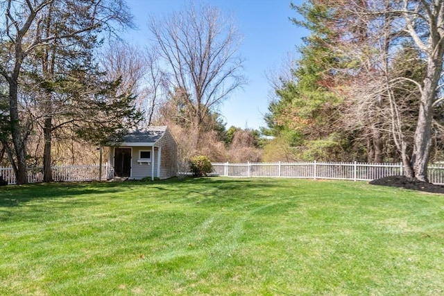 view of yard featuring a fenced backyard, a shed, and an outbuilding