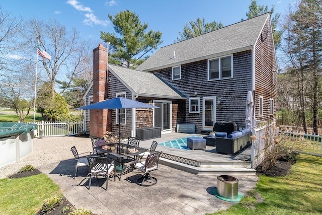 back of property featuring a shingled roof, outdoor lounge area, and a fenced backyard