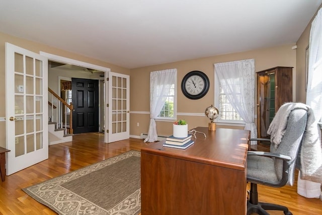 office space featuring french doors, baseboards, and wood finished floors
