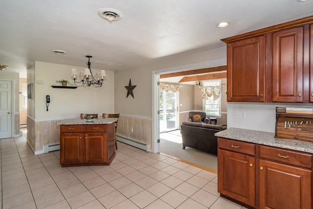 kitchen with a baseboard heating unit, a notable chandelier, and a wainscoted wall