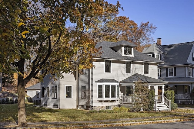 view of front of home with a porch and a front yard