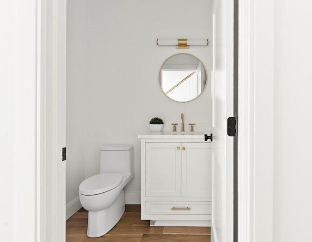 bathroom with toilet, vanity, and hardwood / wood-style flooring