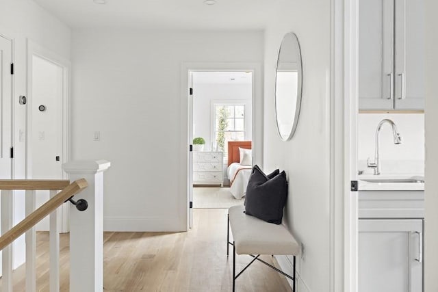 hallway with light hardwood / wood-style flooring and sink