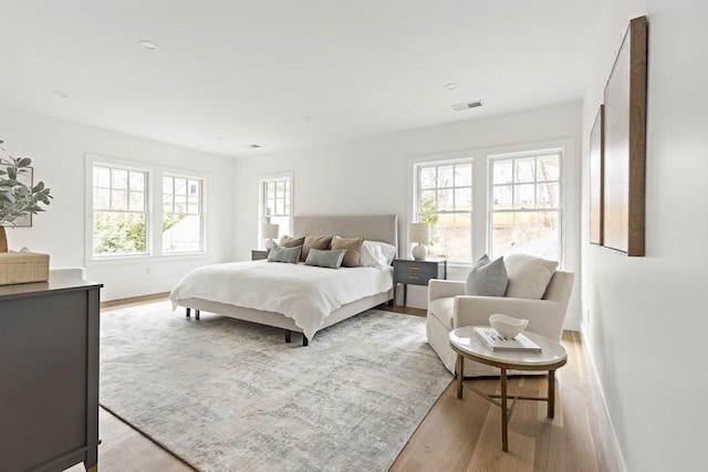 bedroom featuring light hardwood / wood-style flooring and multiple windows