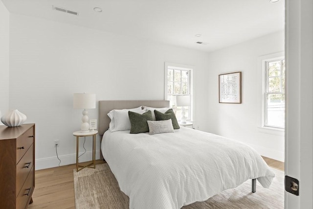 bedroom featuring light hardwood / wood-style floors and multiple windows