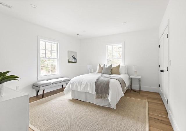 bedroom featuring light hardwood / wood-style floors and multiple windows