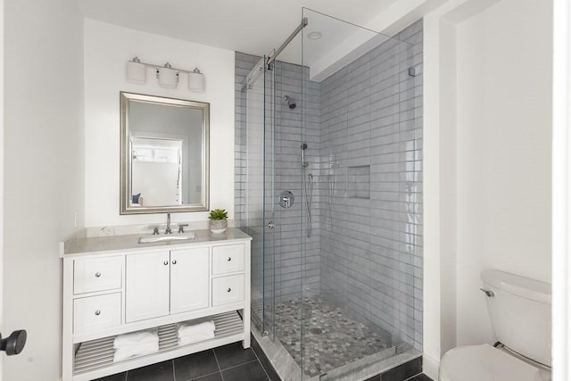 bathroom featuring an enclosed shower, vanity, tile patterned floors, and toilet