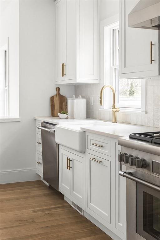 kitchen featuring white cabinetry, ventilation hood, stainless steel appliances, dark hardwood / wood-style floors, and sink