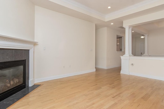 unfurnished living room with crown molding, light hardwood / wood-style flooring, a tile fireplace, and ornate columns