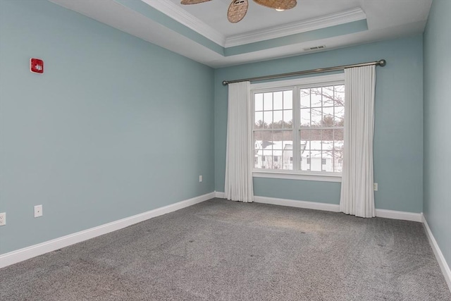 unfurnished room with crown molding, a tray ceiling, and carpet