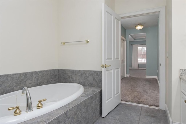 bathroom featuring vanity, tiled bath, and tile patterned flooring