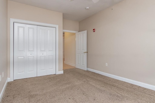 unfurnished bedroom with a closet, ceiling fan, and carpet