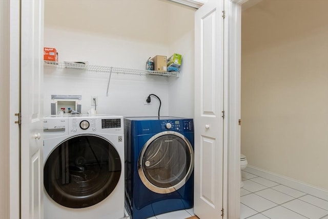 clothes washing area with light tile patterned floors and washing machine and clothes dryer