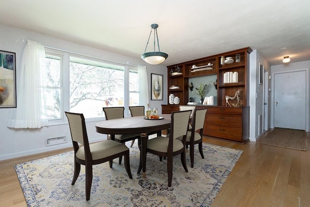 dining room with baseboards and light wood finished floors