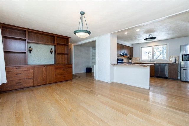 kitchen featuring tasteful backsplash, light wood-type flooring, a peninsula, stainless steel appliances, and recessed lighting