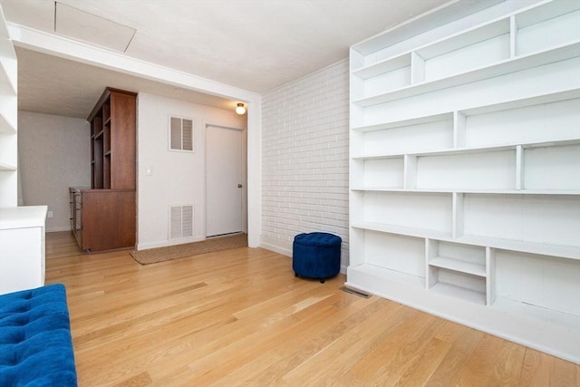interior space with light wood-style floors, baseboards, and visible vents