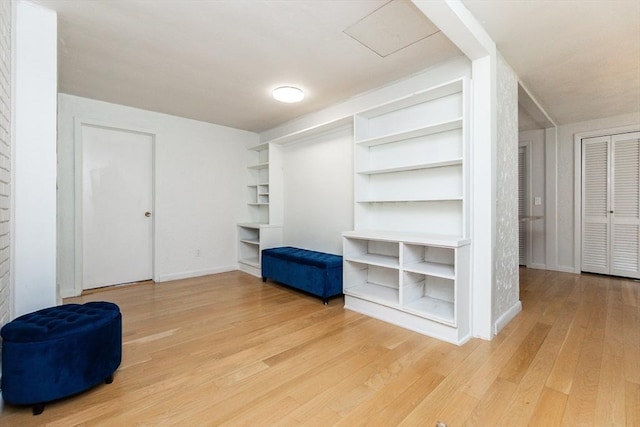interior space featuring baseboards, built in features, and light wood-style floors