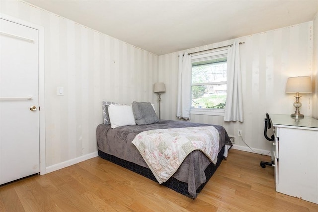 bedroom with baseboards and light wood-style flooring