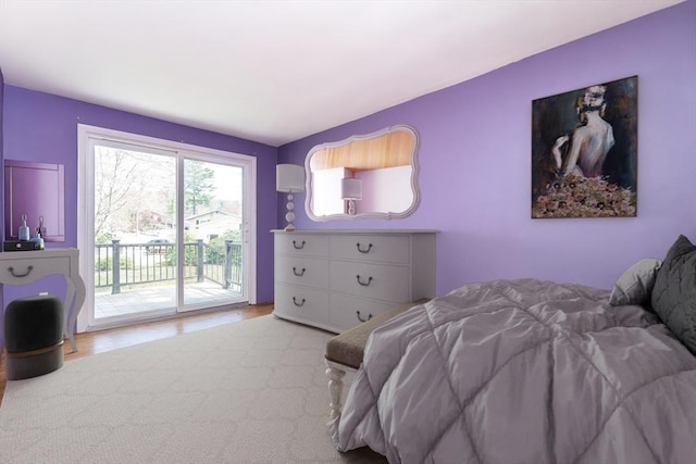 bedroom featuring access to outside and wood finished floors