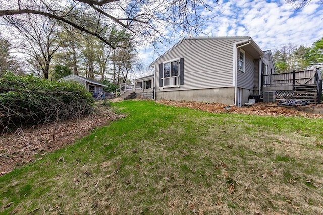 view of side of property featuring stairs, a wooden deck, and a yard