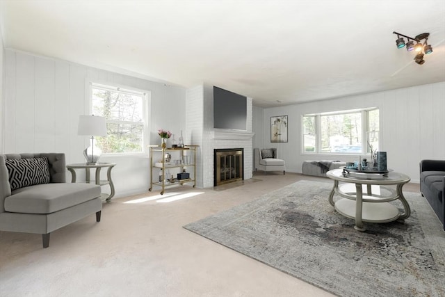 carpeted living area featuring a brick fireplace and a wealth of natural light