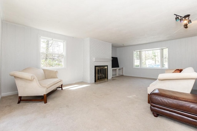 living area with carpet flooring, a brick fireplace, and a healthy amount of sunlight