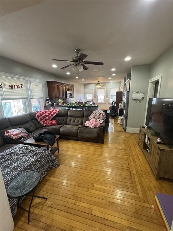 living area with light wood-style flooring and recessed lighting