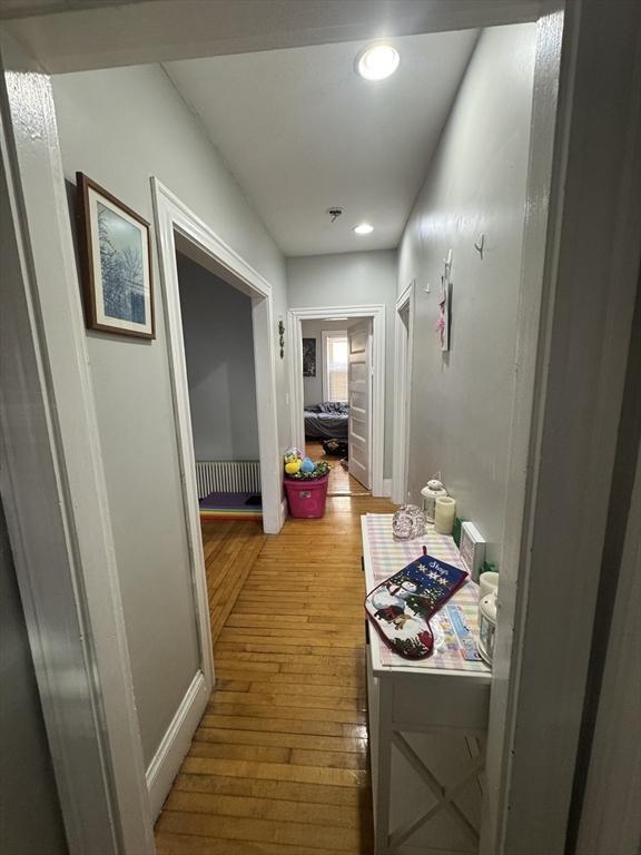 corridor featuring recessed lighting, baseboards, and light wood finished floors