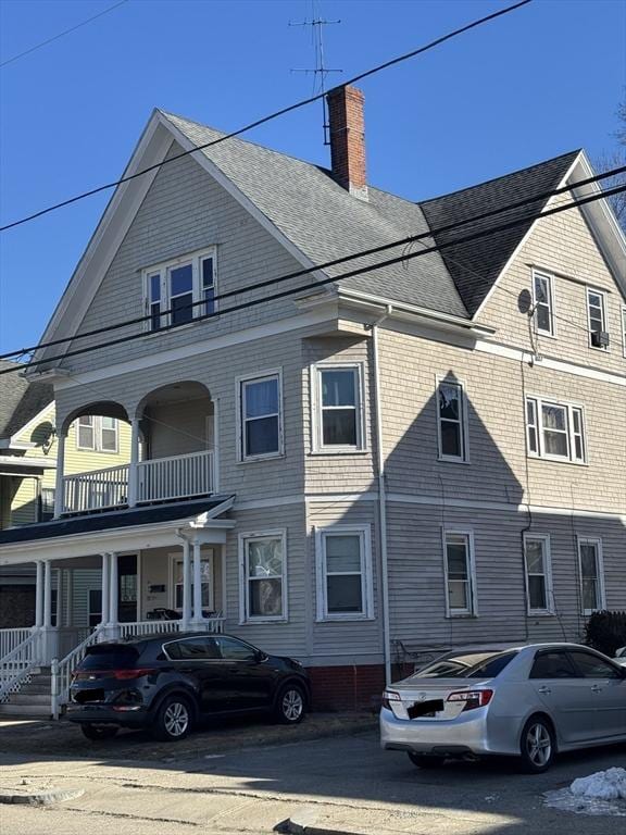 multi unit property with a shingled roof and a chimney