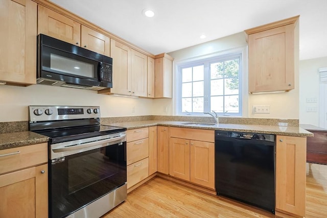 kitchen with stone countertops, light brown cabinetry, sink, black appliances, and light wood-type flooring