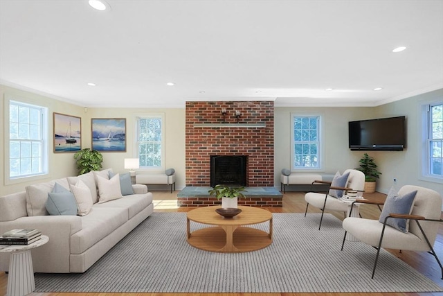 living room featuring a brick fireplace, a wealth of natural light, and light wood-type flooring