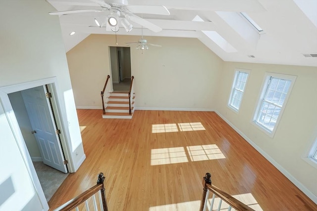 additional living space with vaulted ceiling with skylight and light hardwood / wood-style flooring