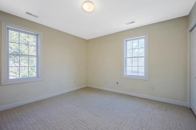 empty room with a healthy amount of sunlight and light carpet