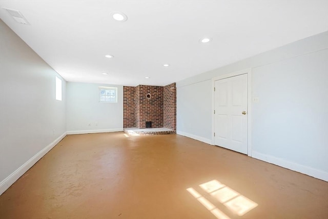 unfurnished living room featuring a brick fireplace and concrete floors