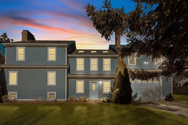 back house at dusk featuring a yard