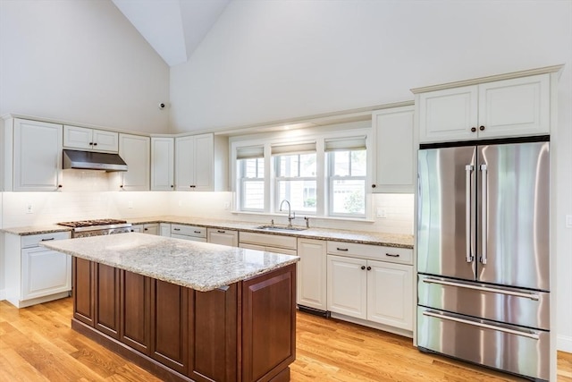 15 Hydrangea Cir, Falmouth, MA 02536 - kitchen with stainless steel refrigerator, a sink, under cabinet range hood, light wood finished floors, and decorative backsplash