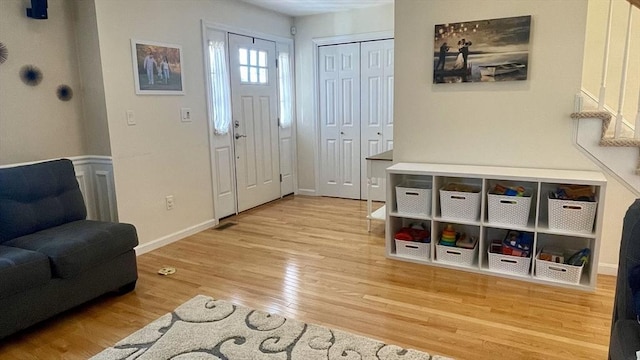 entryway featuring stairs, baseboards, and wood finished floors