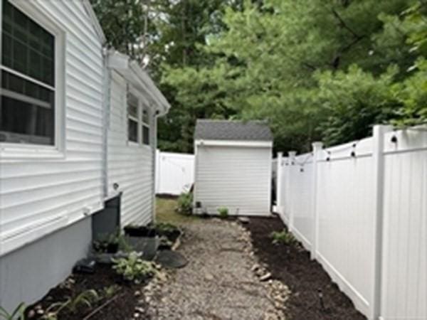 view of side of home with a storage shed