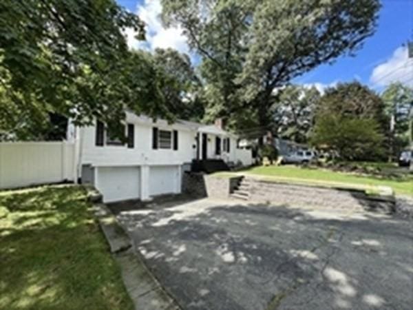 split foyer home with a garage and a front lawn