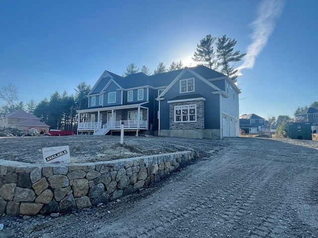 rear view of house with a porch and a garage