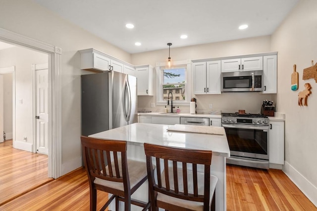 13 Darling St, Acushnet, MA 02743 - kitchen featuring stainless steel appliances, a sink, light countertops, light wood-type flooring, and baseboards