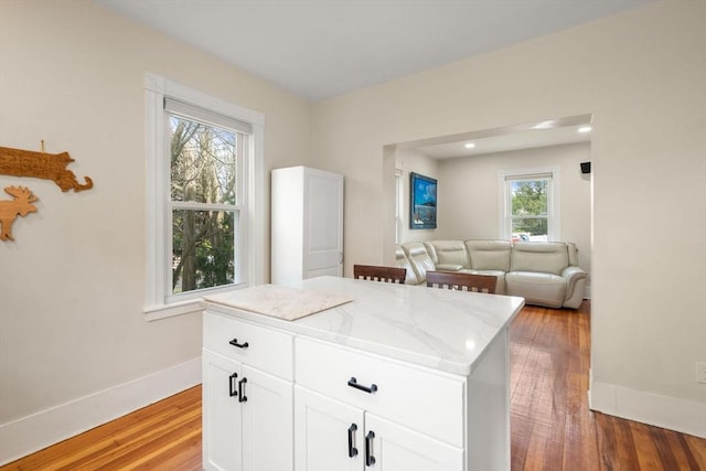 13 Darling St, Acushnet, MA 02743 - kitchen featuring baseboards, light wood-style flooring, white cabinets, a center island, and open floor plan