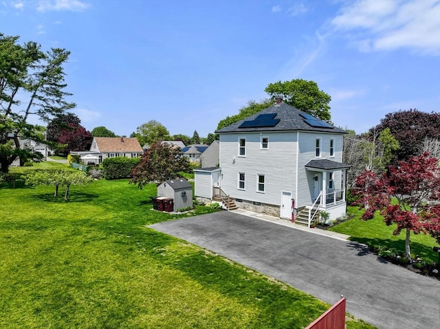 13 Darling St, Acushnet, MA 02743 - back of property featuring solar panels, a yard, and a chimney