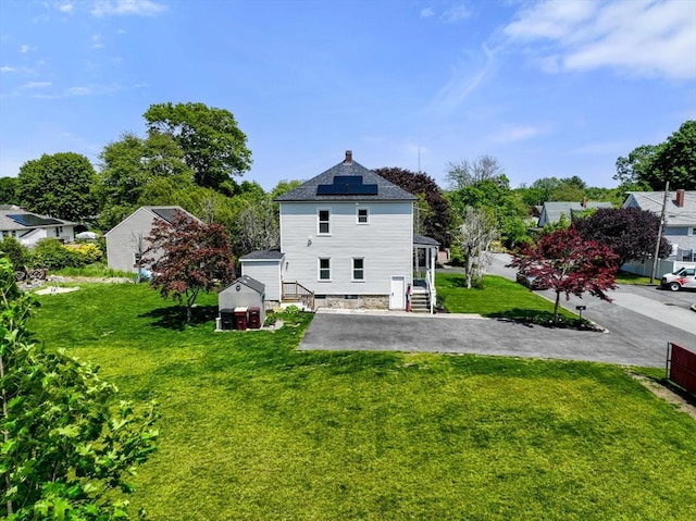 13 Darling St, Acushnet, MA 02743 - rear view of house with solar panels, a lawn, and a shingled roof