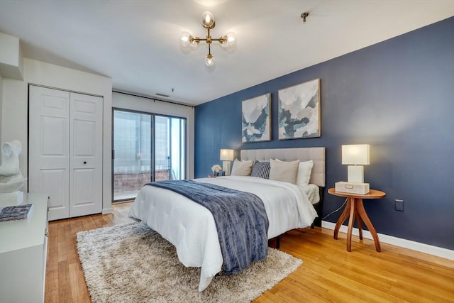 bedroom with access to exterior, baseboards, and wood finished floors