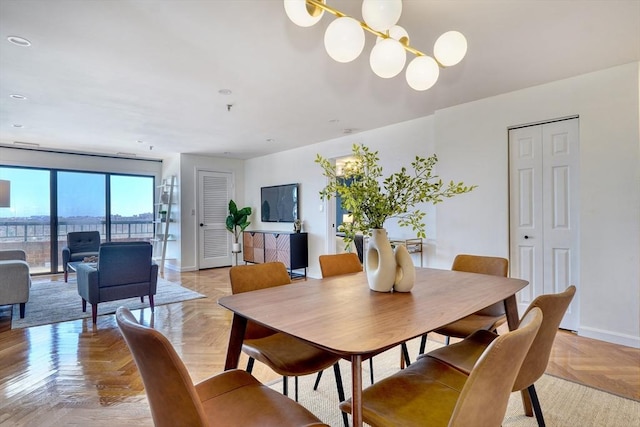 dining area with an inviting chandelier and baseboards