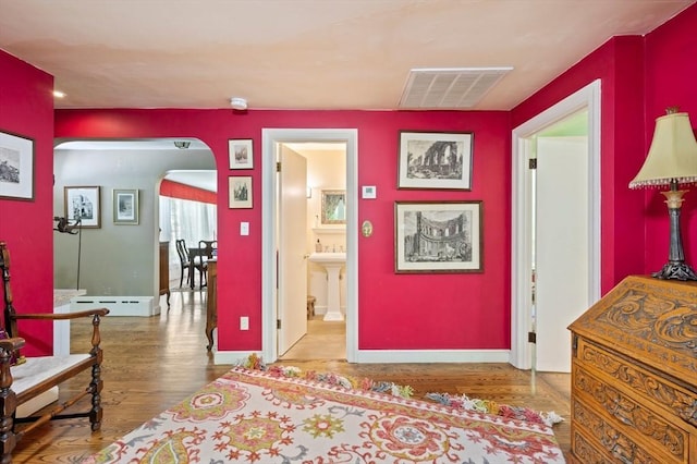 63 Hawthorne, Weymouth, MA 02189 - bedroom with arched walkways, wood finished floors, baseboards, ensuite bath, and a baseboard heating unit