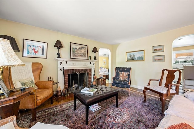63 Hawthorne, Weymouth, MA 02189 - living room featuring arched walkways, wood finished floors, a brick fireplace, and baseboards