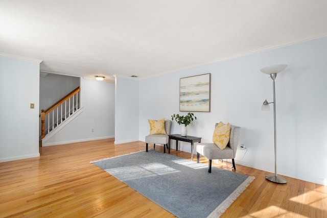 sitting room with wood-type flooring and ornamental molding