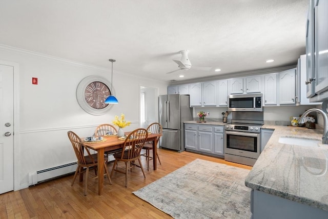 kitchen featuring crown molding, sink, decorative light fixtures, and stainless steel appliances